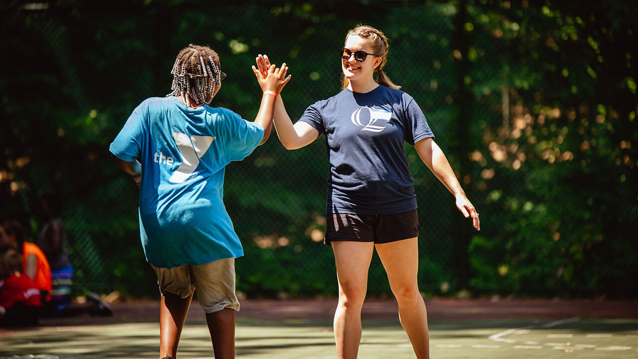 A student cheers on a camper as they run