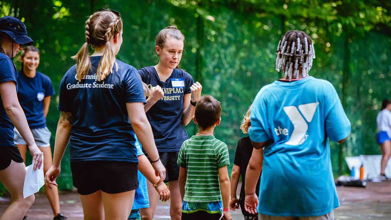 Students explain different field day games to campers