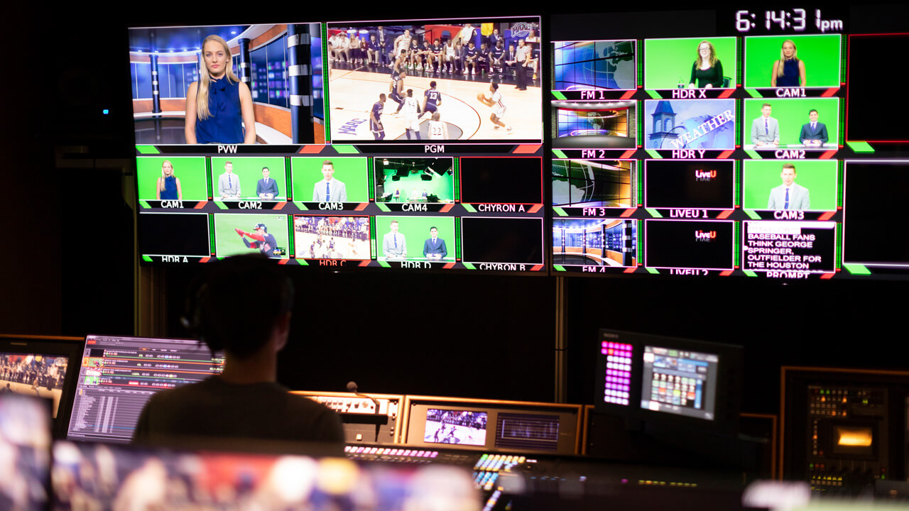 A photo of the media control room with many screens