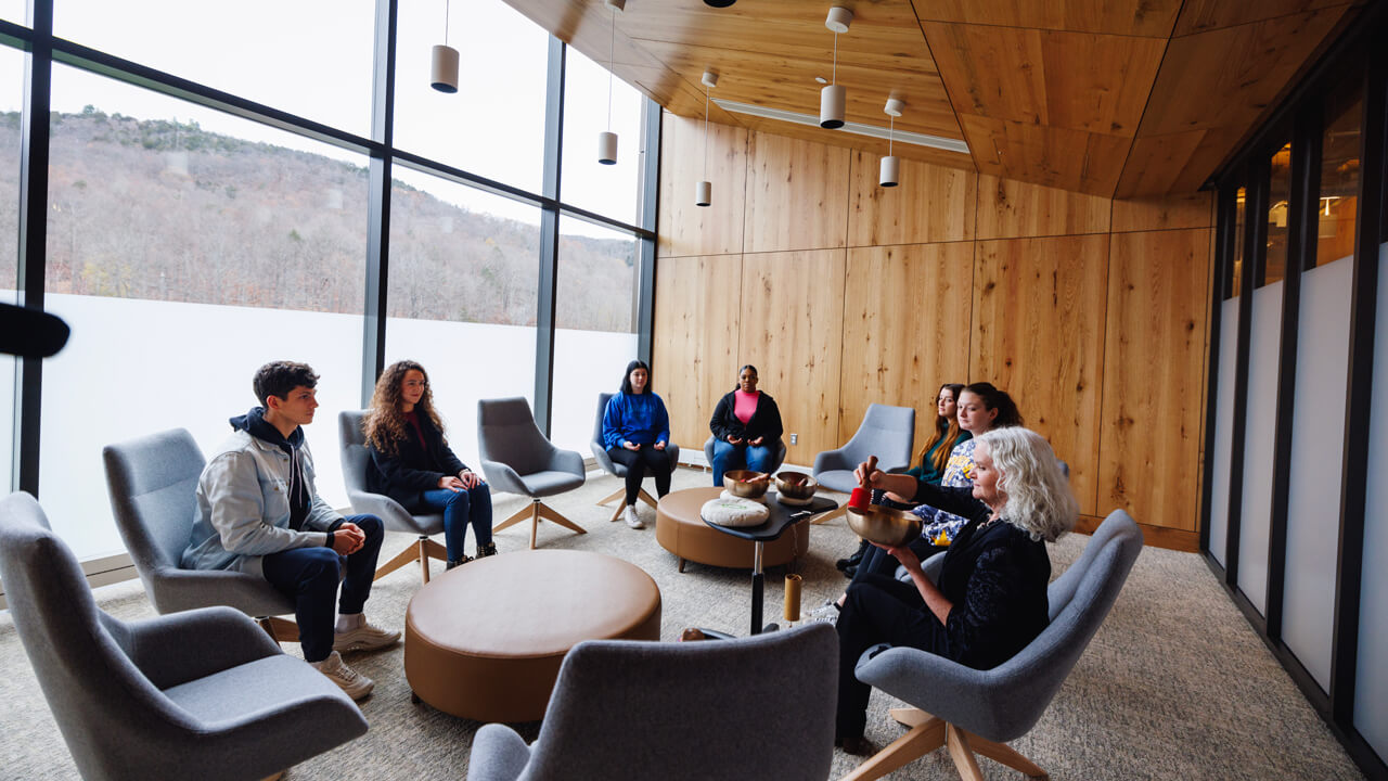 A group of students and a therapist participate in group therapy