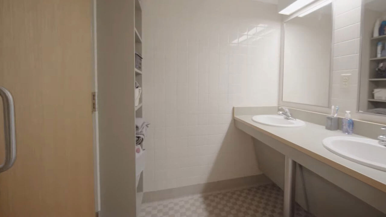 A bathroom in townhouse showing 2 sinks and storage space