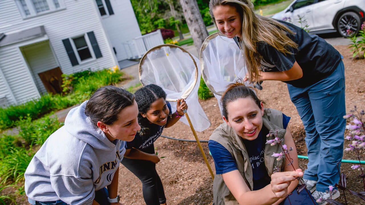 Students crouched over inspecting flower