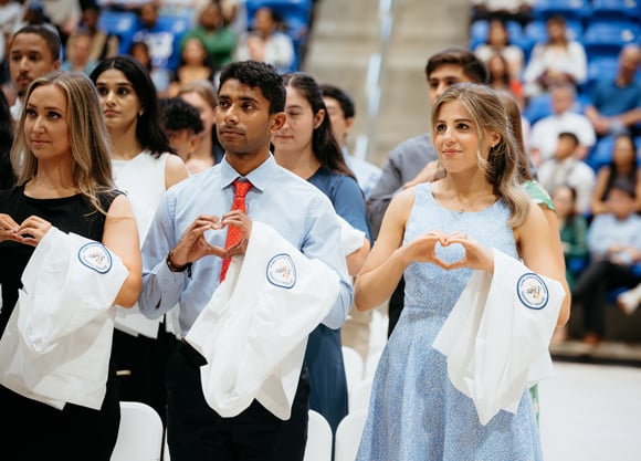 Students hold up their hands to make a heart