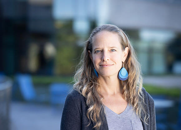 Professor Amber Kelly poses for a headshot outside.