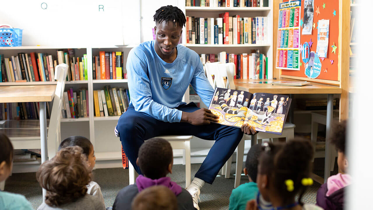 Abdulai Bundu reads a book to a class of children