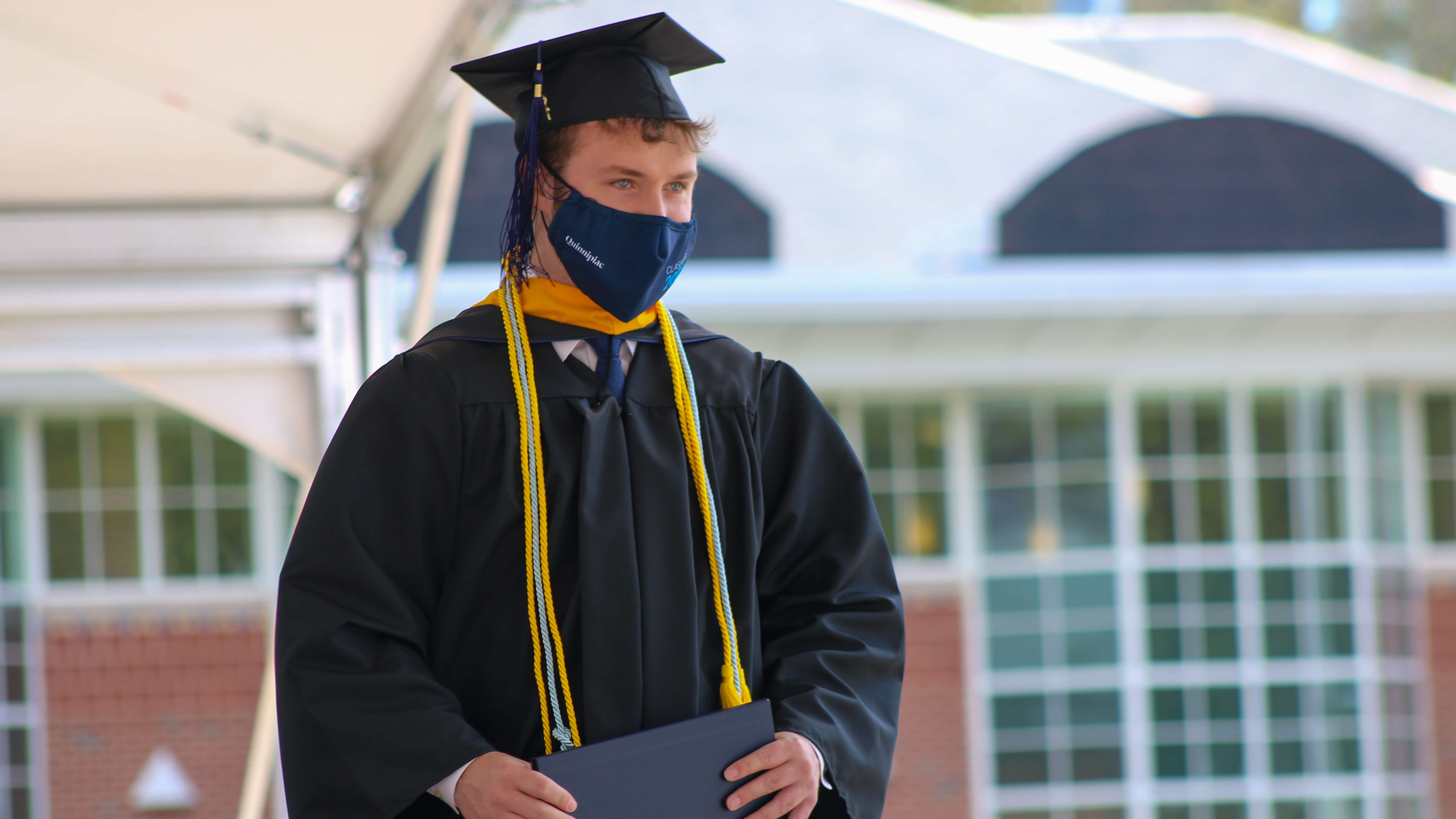 Alumnus Kyle Del Balso walking across the stage at commencement