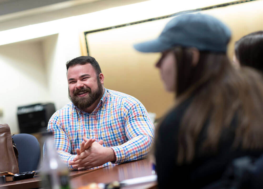 Hoffman laughs while speaking with students.