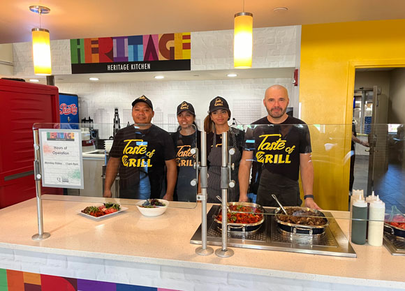 Taste of Grill staff members smile in front of new Heritage Kitchen