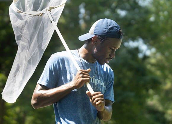 Khristoff Lawes in a backwards hat while holding a fishing net