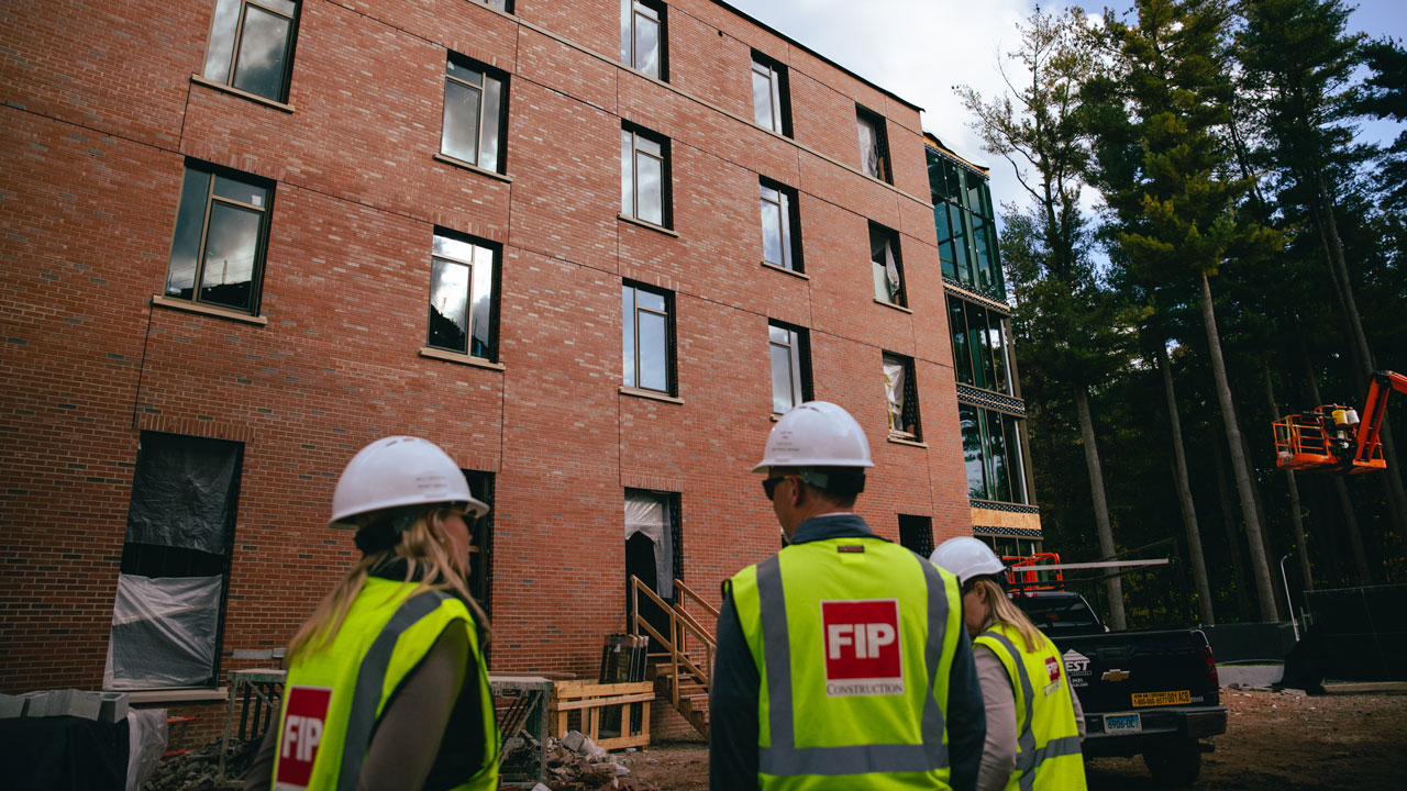 Construction workers talk near one of the new south quad buildings being built.