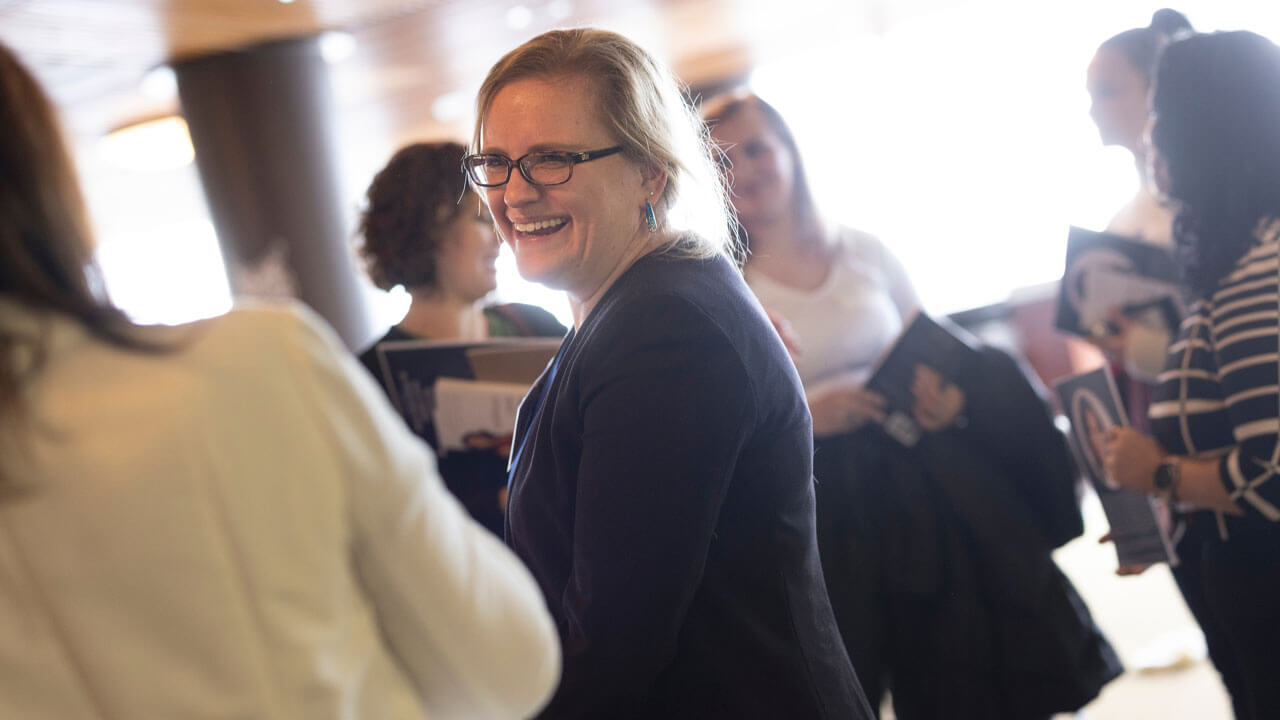 Professor Fullick smiling and talking to other business professionals