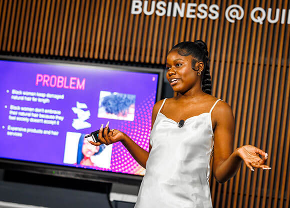 A student gestures while giving a presentation