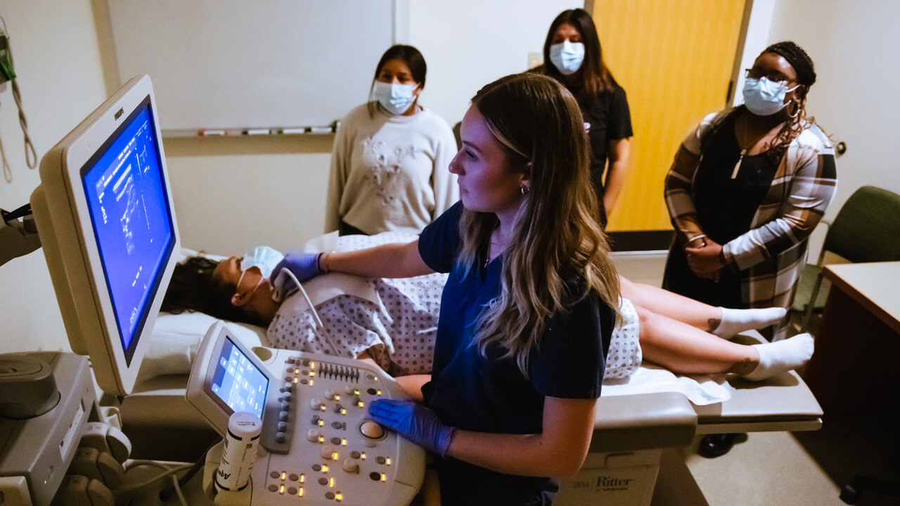 Students watch as DMS student performs an analysis on her patient.