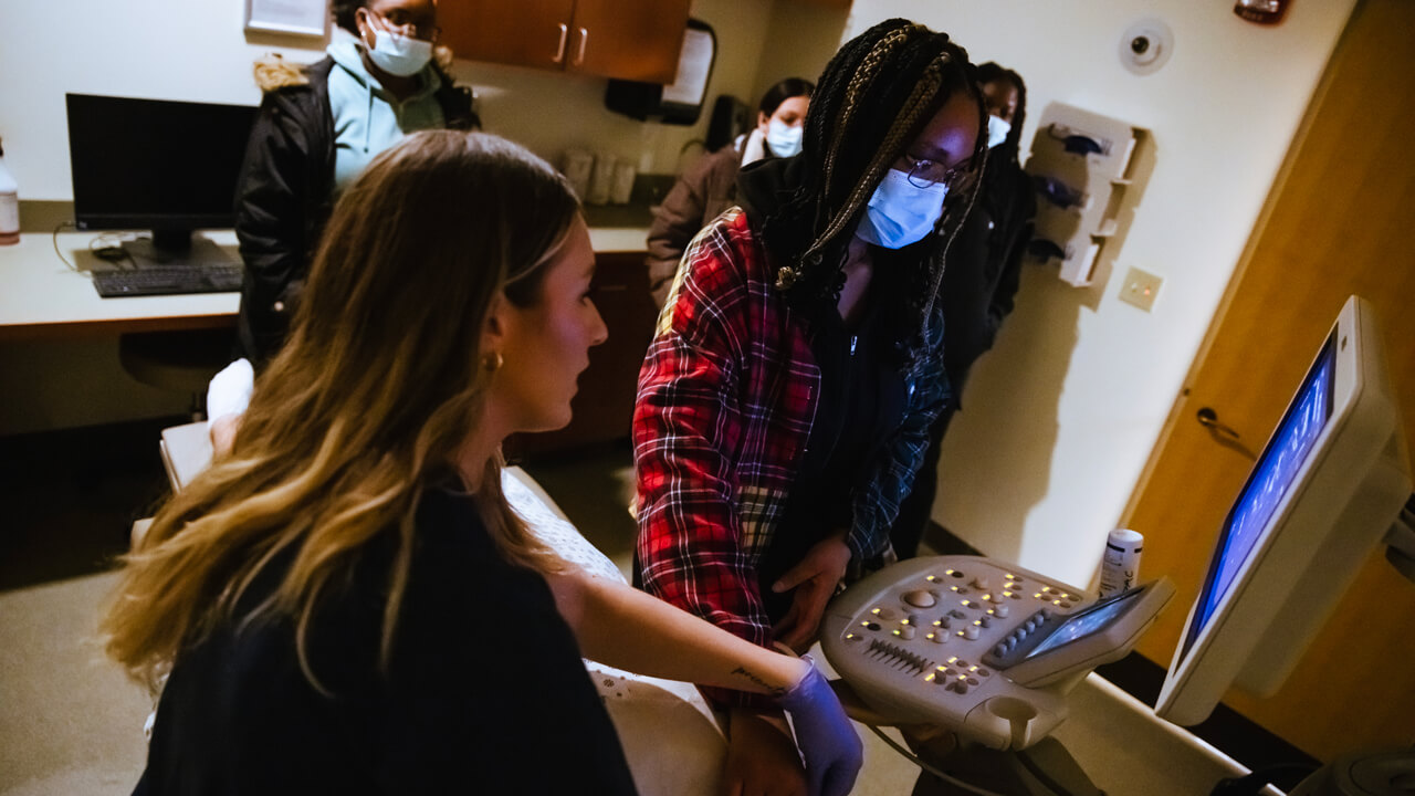 Student being taught how to use a sonograph digital imaging system.