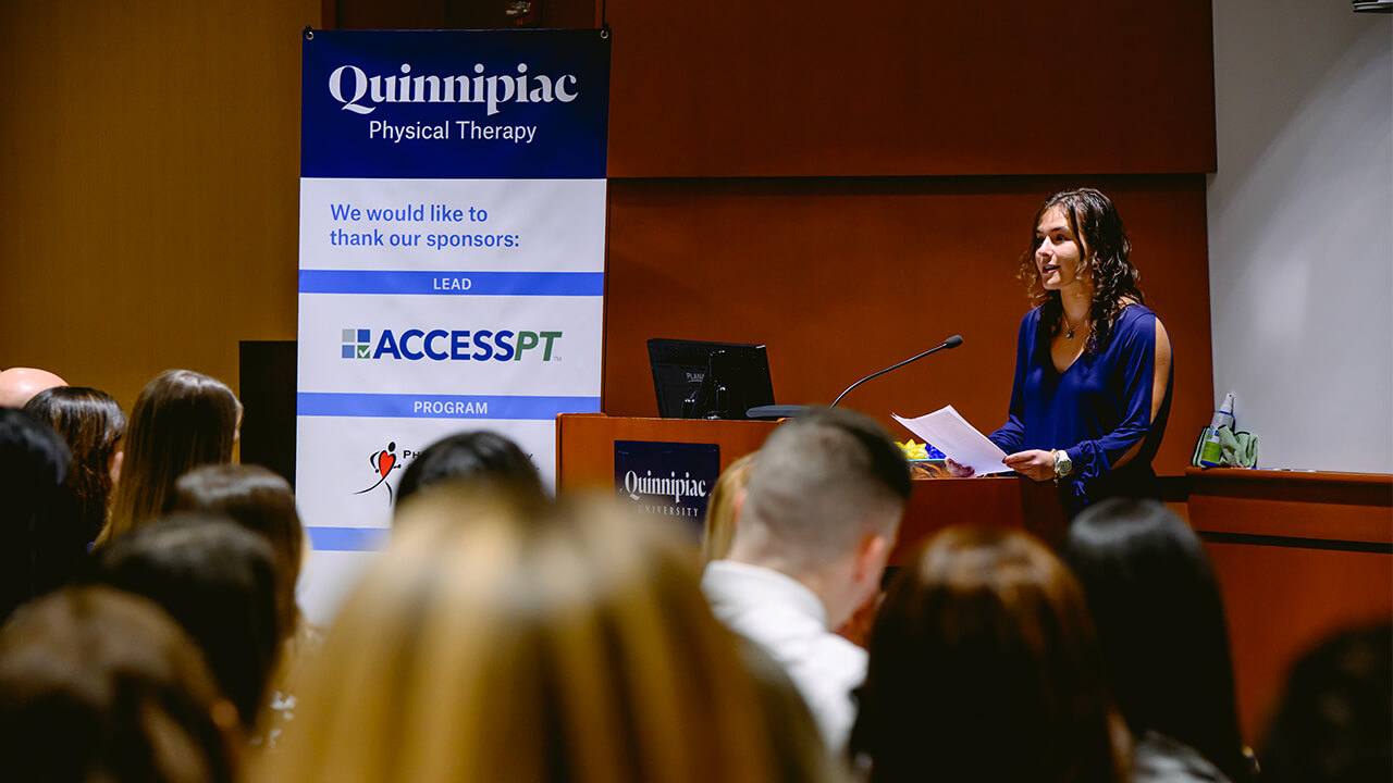 Student stands on a podium giving a speech.