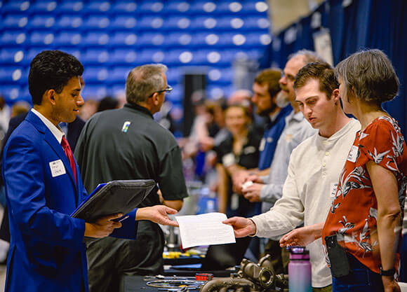 Student handing his resume to potential employer