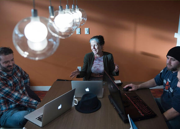 Elena Bertozzi sits at a table with 4 other students in the conference room in the Center for Innovation and Entrepreneurship