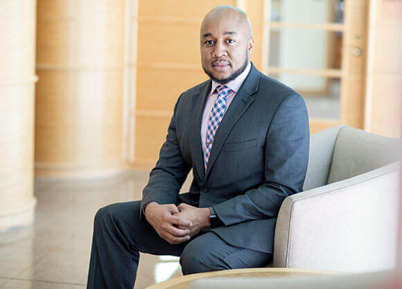 Don C. Sawyer III sits in a chair in the lobby of the Center for Communications and Engineering.