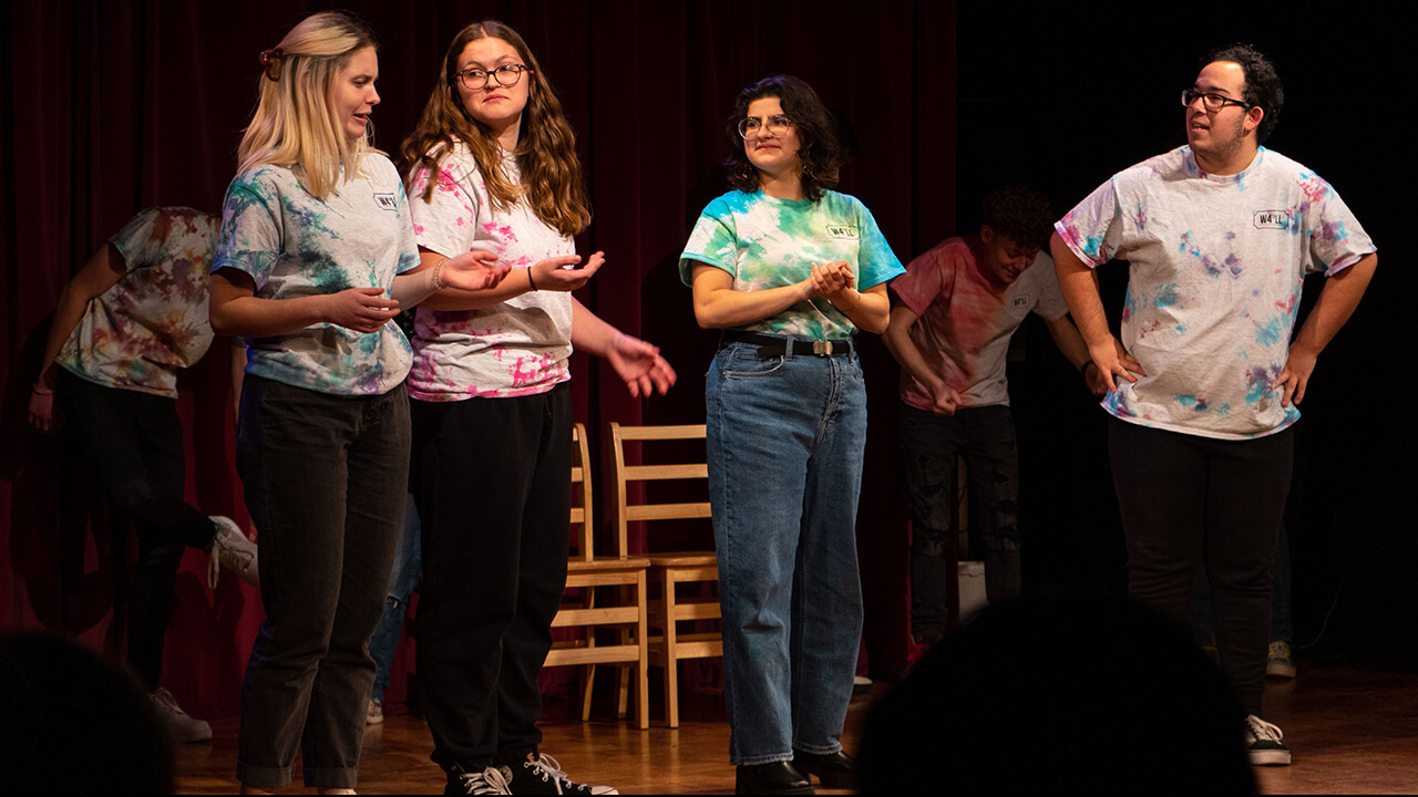 Students stand on stage