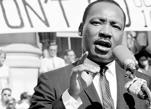 Dr. Martin Luther King, Jr., gestures with his hand during a speech.