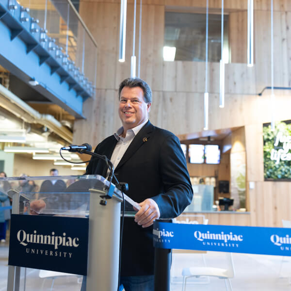 Robert Potter grins while standing at the podium in the Recreation and Wellness Center lobby