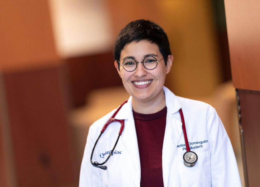 Headshot of Delilah Dominguez wearing a white coat and a stethoscope