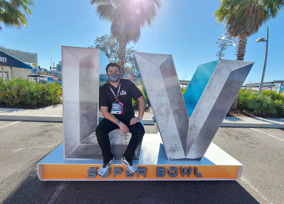 Ahearn sits on a Super Bowl sign