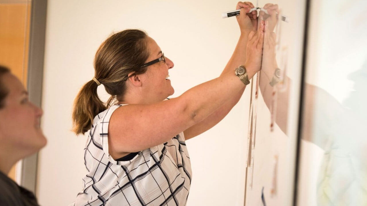 New Haven middle school teacher Heather Toothaker writing on whiteboard