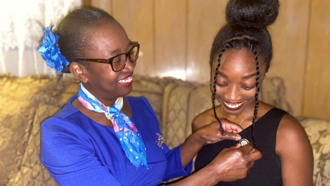 Hadassah Cormier getting her pin placed on her shirt while sitting on a couch