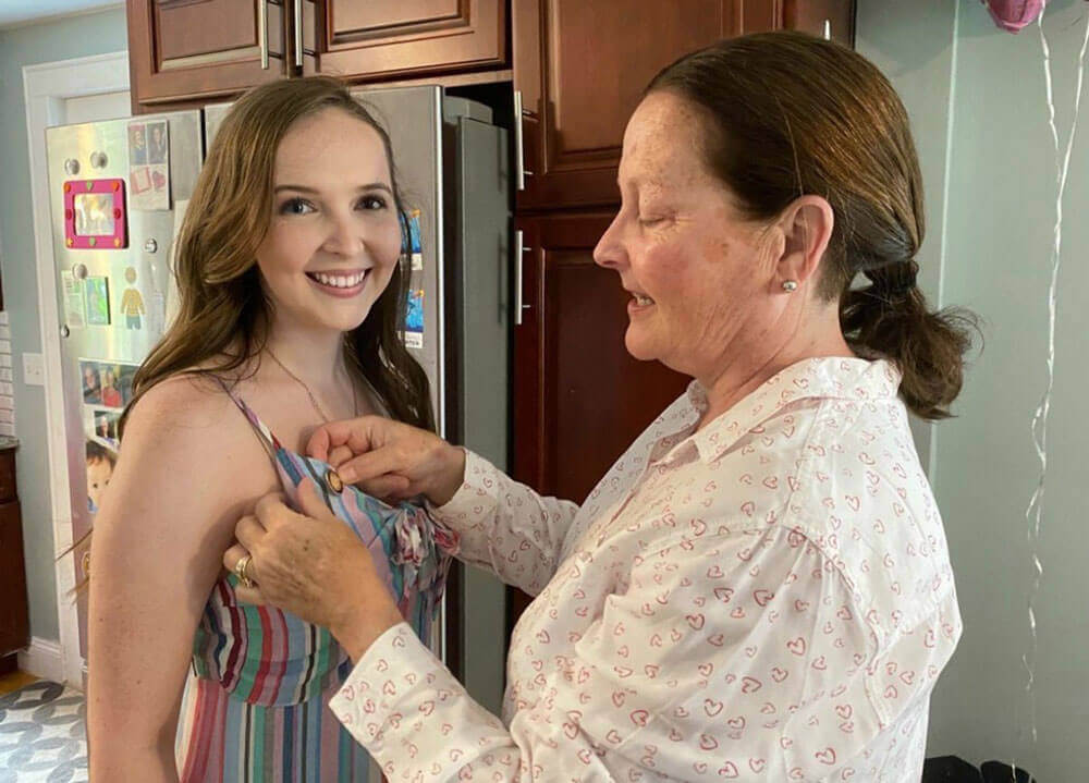 Megan Coakley getting her pin put on her shirt in her kitchen