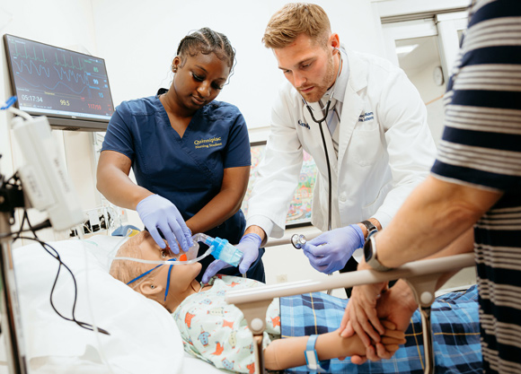 Health science students tend to their manikin patient in the simulation suite