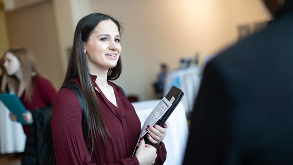 A female student holding a resume cover