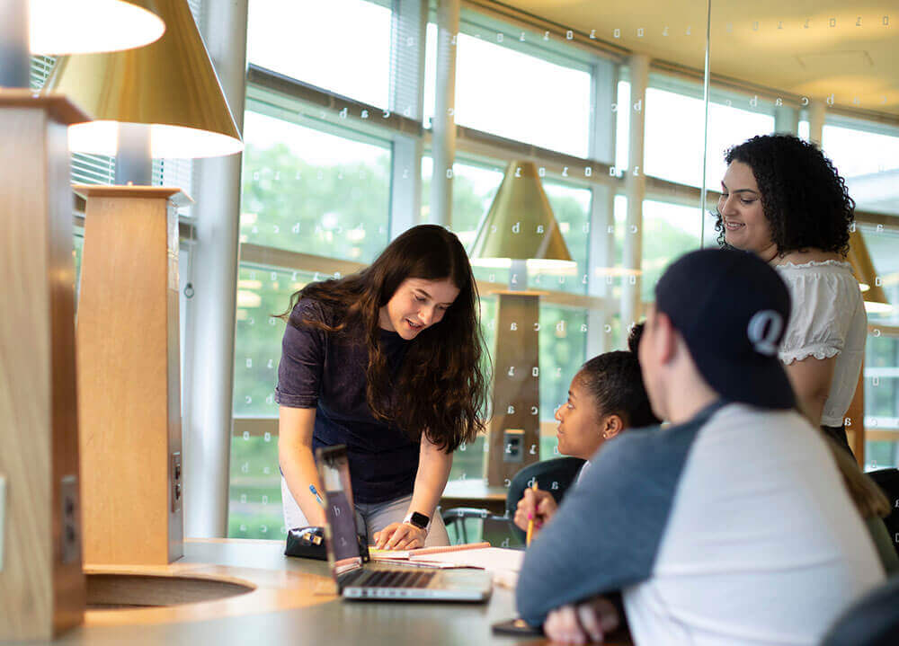 A group of students collaborate on a project together in the library