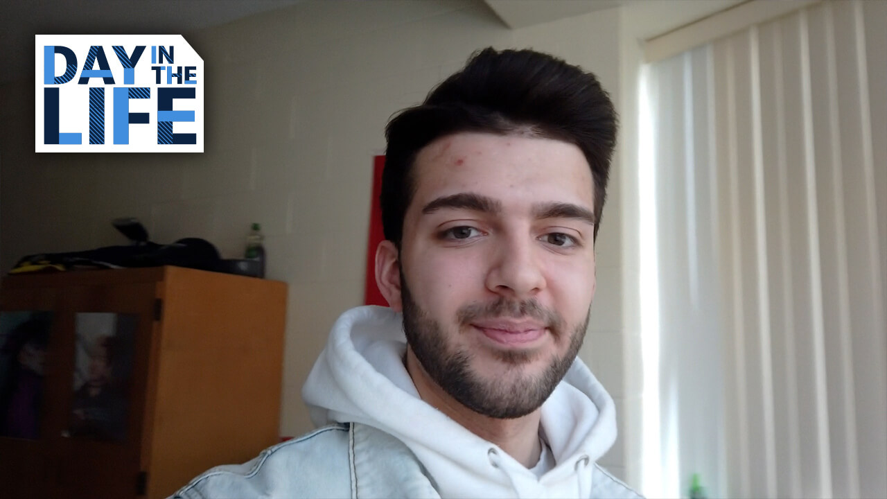 Student smiling in a dorm room for a video feature