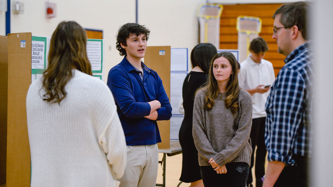 A group of students present their project to faculty and student attendees.