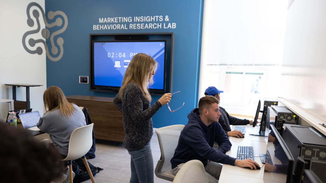 A professor speaking to a student in the Marketing Insights and Behavioral Research Lab