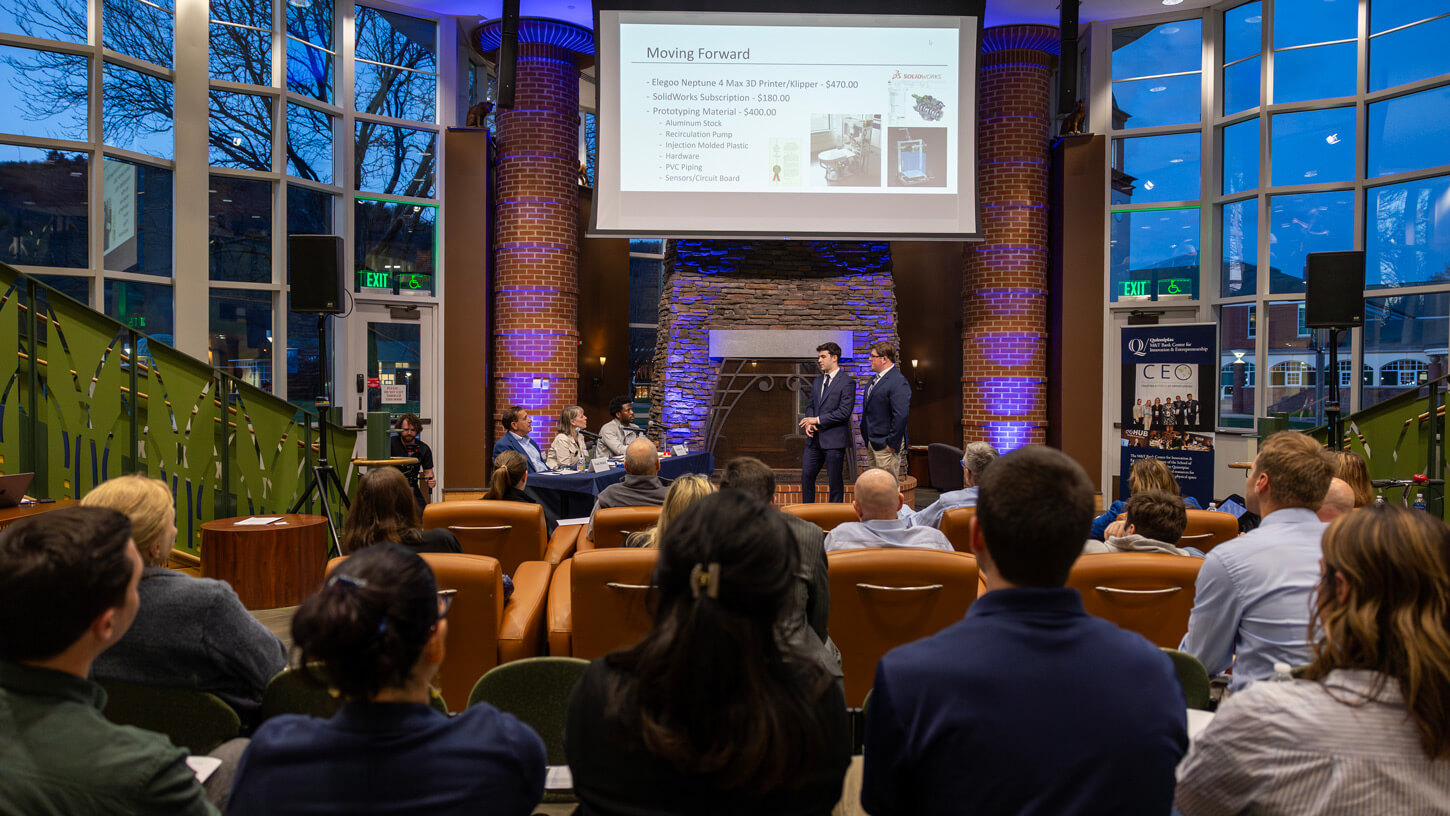 Students watch their peers participating in a pitch competition