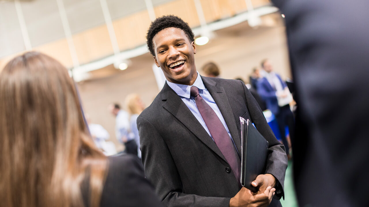 A student smiles during a career fair in the Recreation Center Courts on Quinnipiac’s Mount Carmel Campus