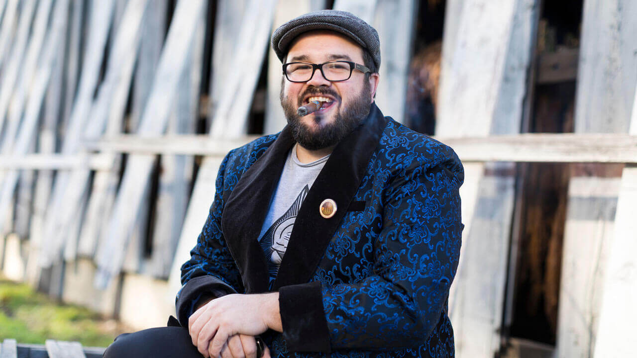 Nicholas Melillo smiles in front of one of his tobacco barns