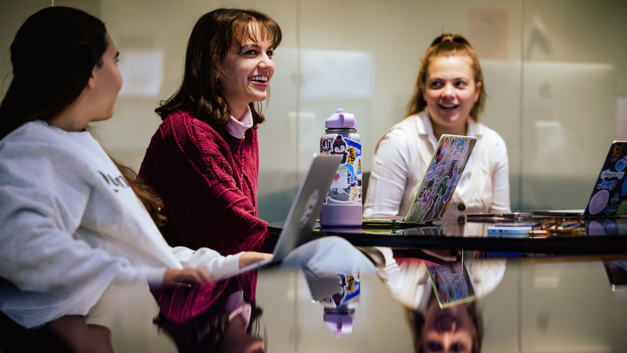 Students collaborating during a meeting for The Agency in the School of Communications.