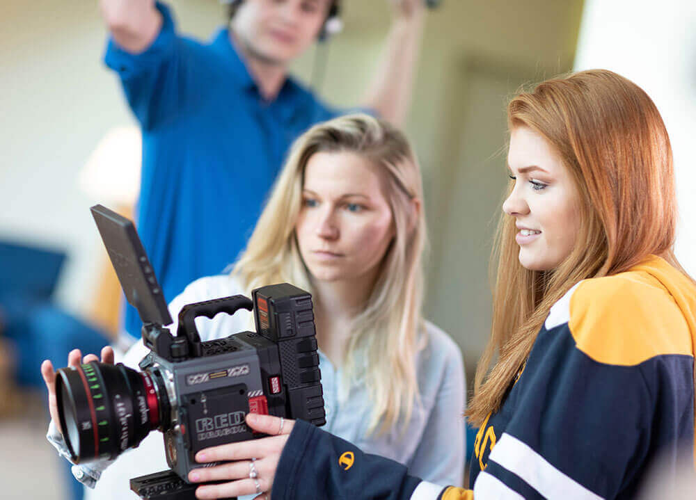 Film, tv and media arts professor Ashley Brandon helps a student with an HD camera