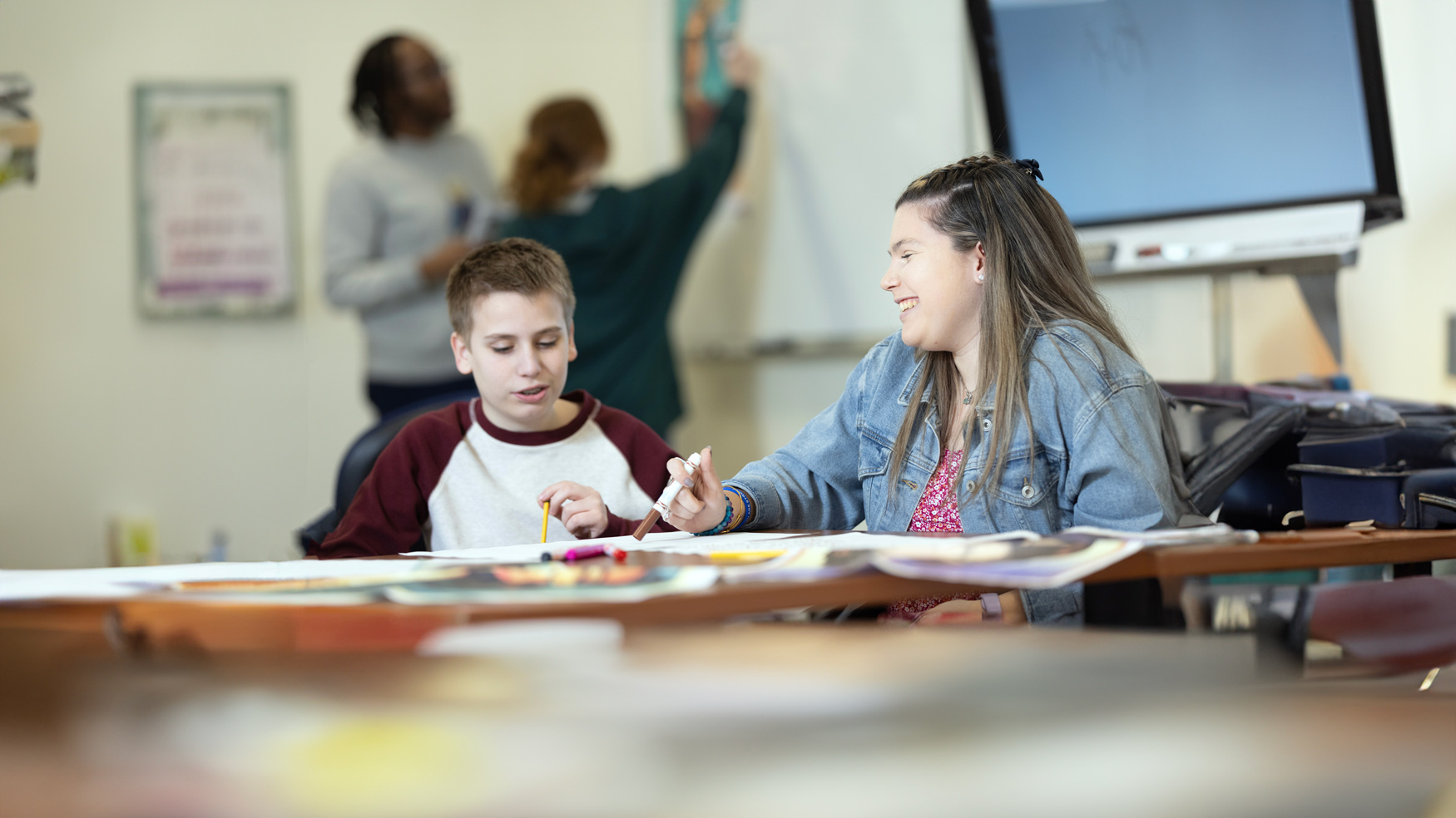 A Quinnipiac graduate student mentors a child in a grade-school classroom