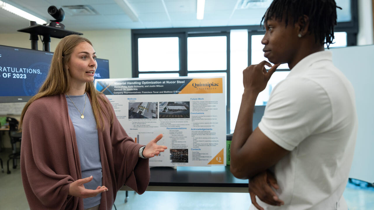 A student presents their project to another student.