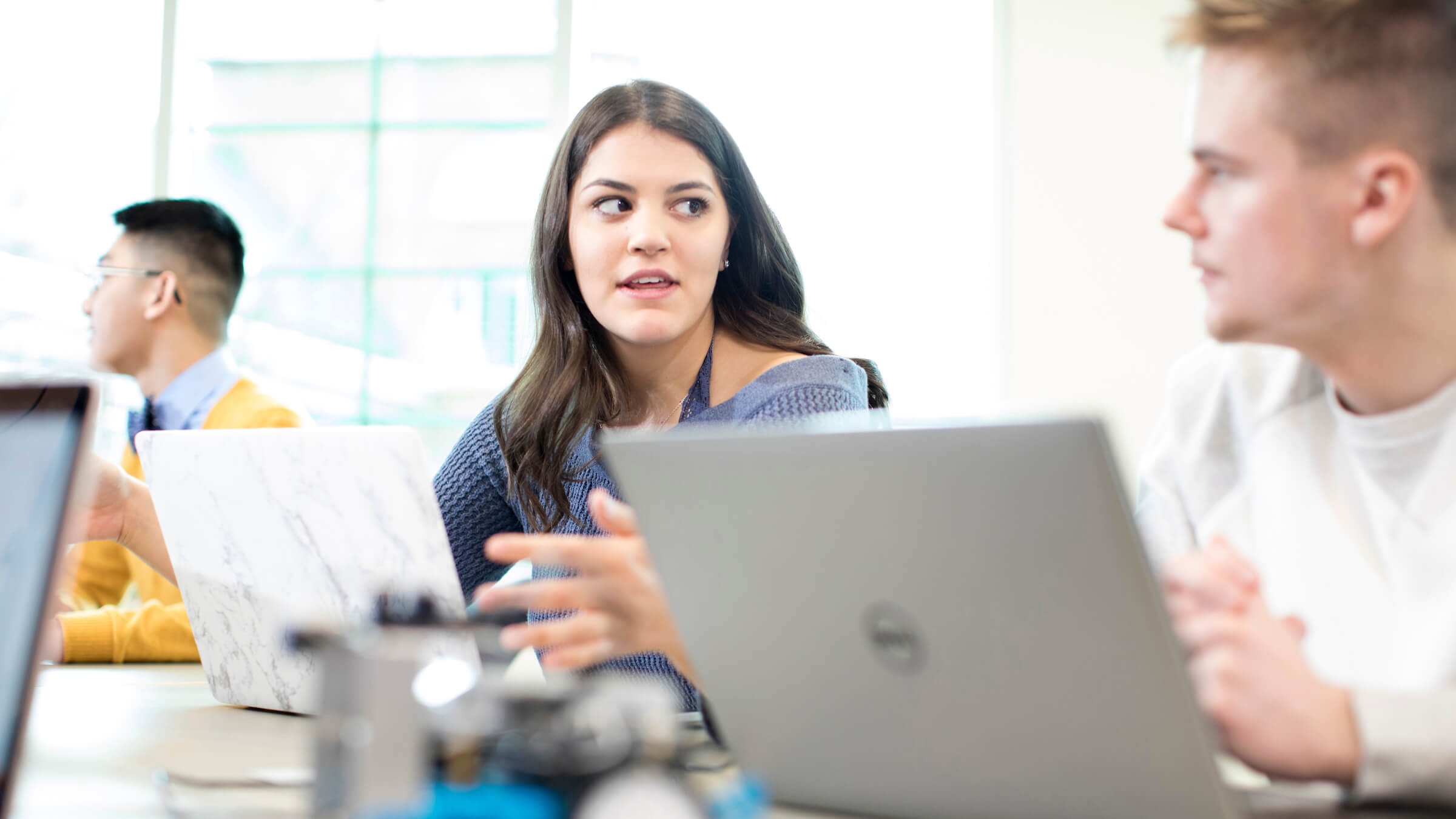 Students in classroom with laptop and robot on desk