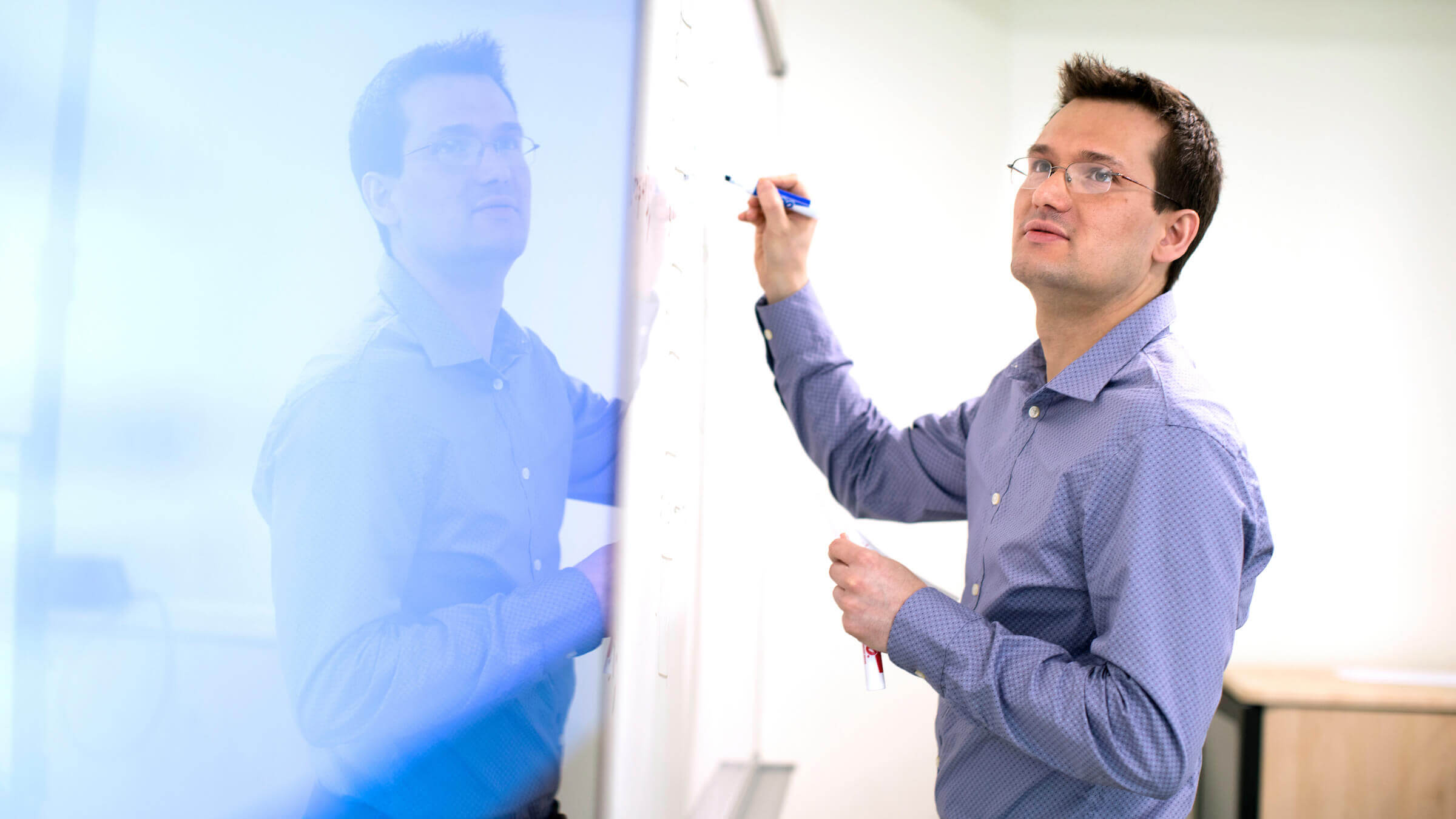 Professor writes on board during class