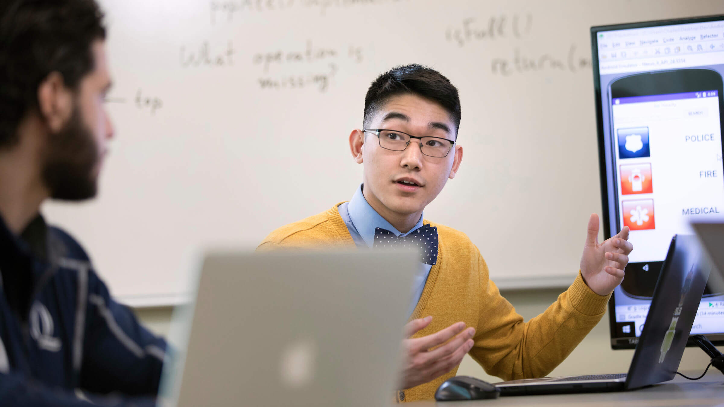 Student in classroom sitting in front of a laptop