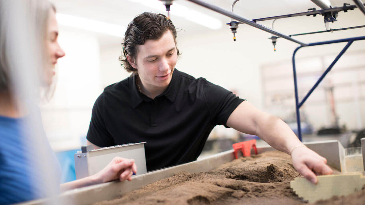 A student using the water flow and climate simulation table