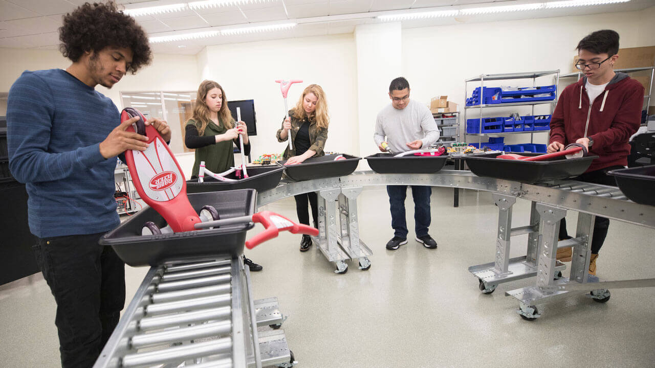 Students assembling scooters on the assembly line