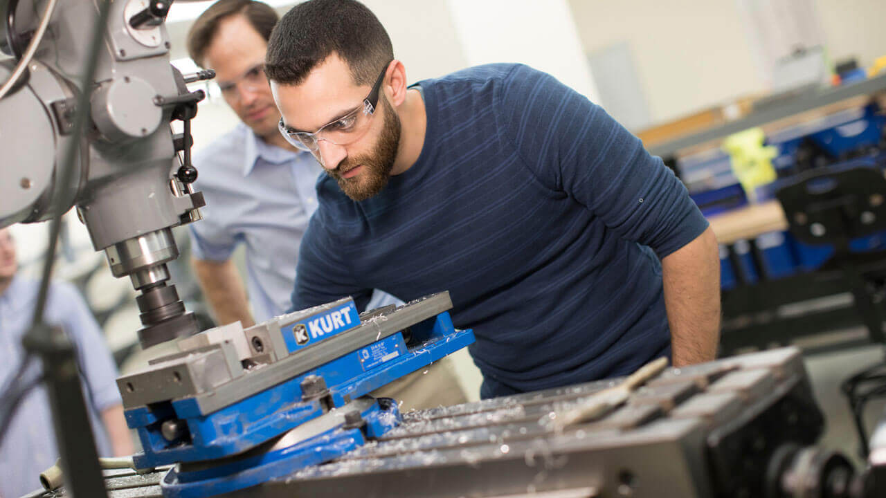 Student working on machinery in a classroom