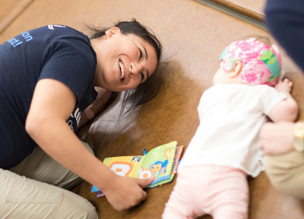 Student plays with an infant as part of OT instruction and therapy demonstrations in the Movement Lab